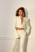 Woman wearing a white suit against a light background