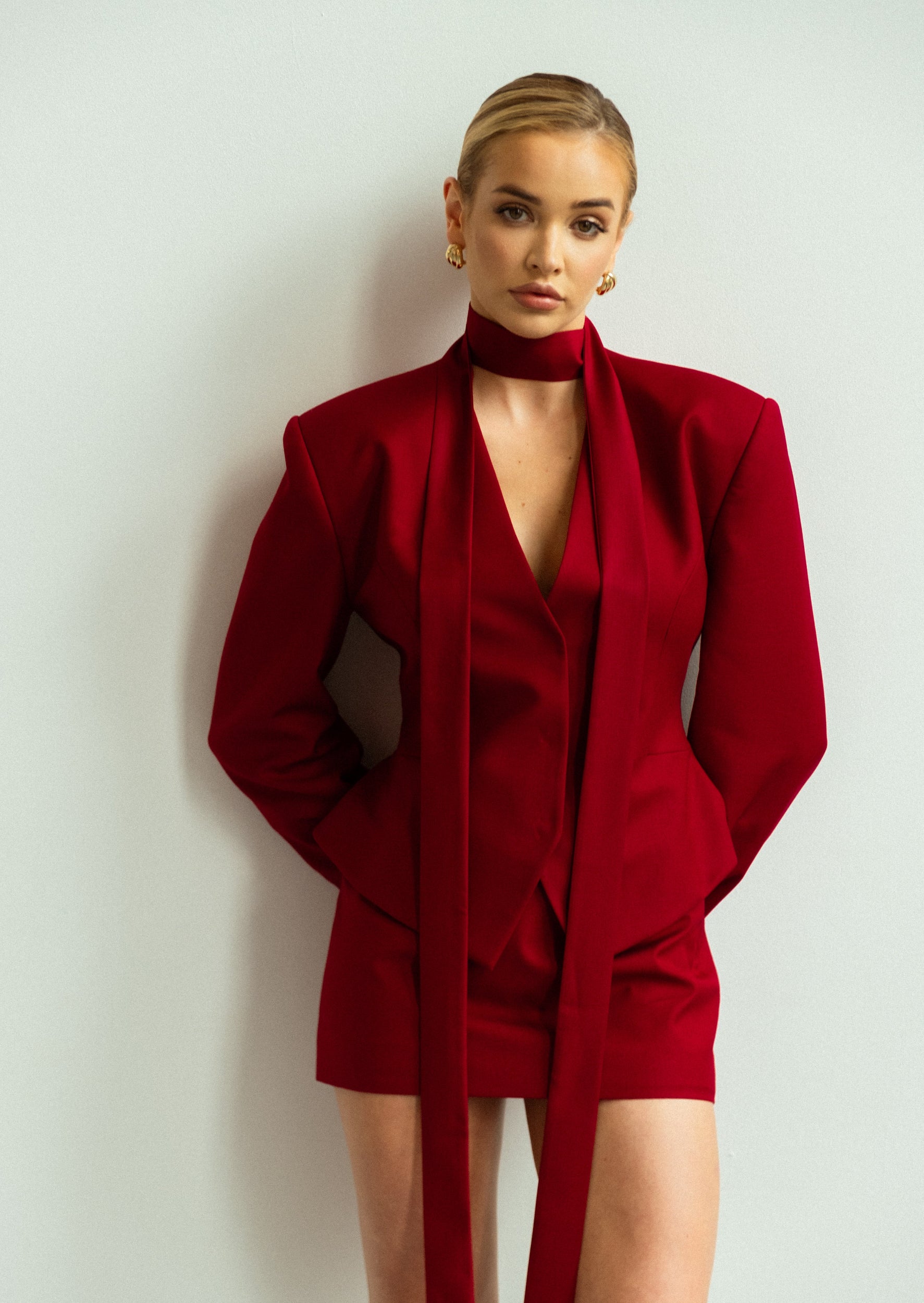 Woman wearing a red outfit against a plain background