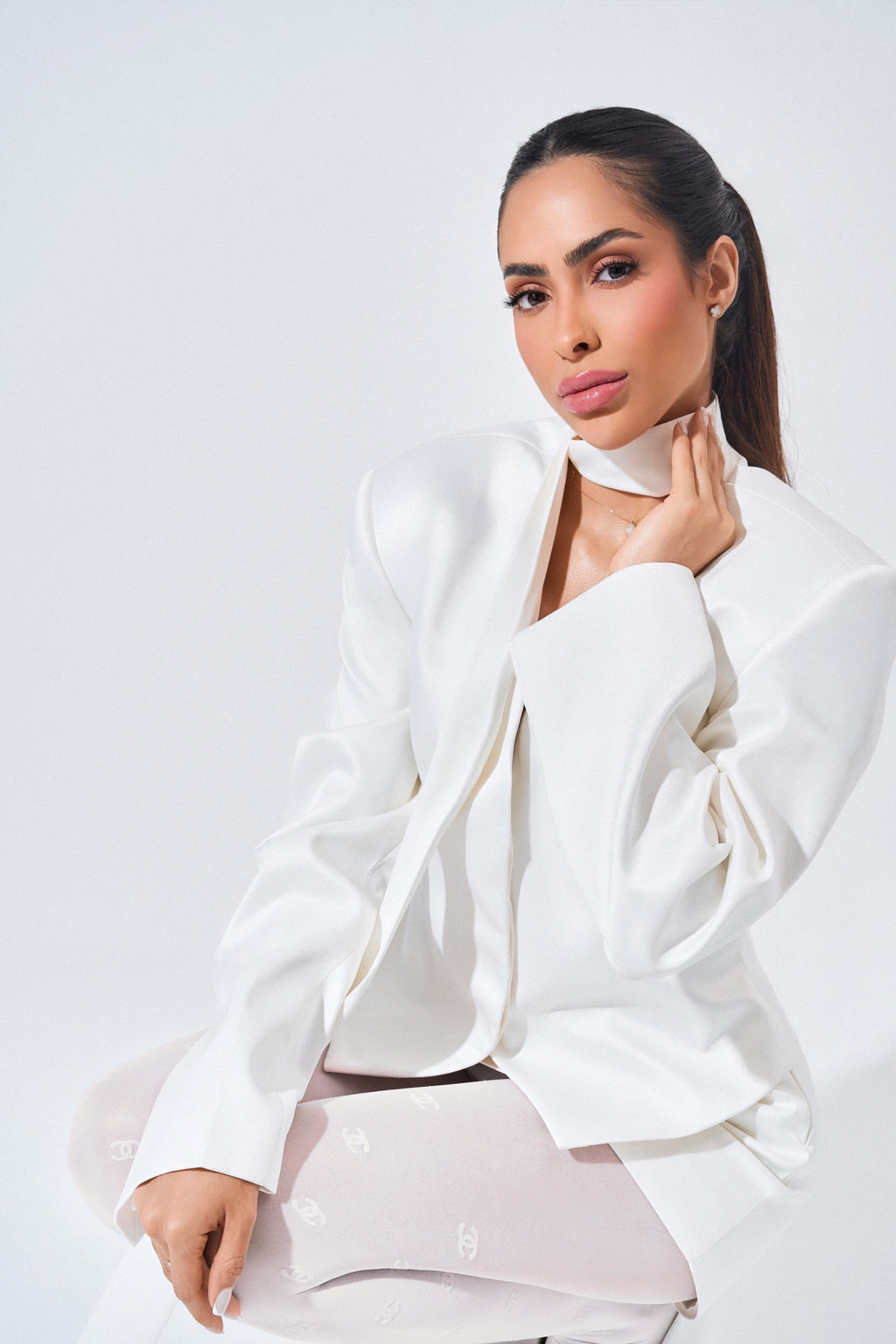 Woman wearing a white outfit against a plain background